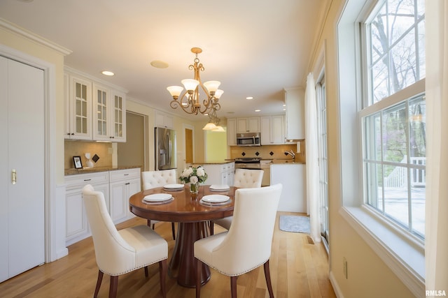 dining room with crown molding, recessed lighting, a notable chandelier, and light wood-type flooring