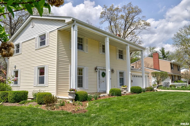 neoclassical home featuring a garage, covered porch, a chimney, and a front yard