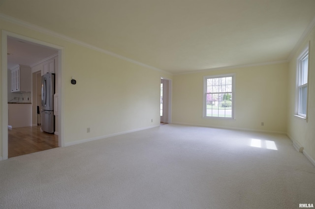 empty room with baseboards, light carpet, and plenty of natural light