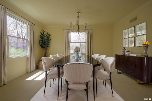 dining area featuring an inviting chandelier, crown molding, visible vents, baseboards, and light colored carpet