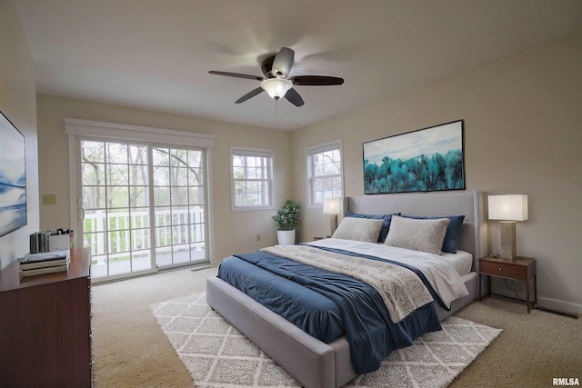 carpeted bedroom featuring baseboards, visible vents, a ceiling fan, and access to outside