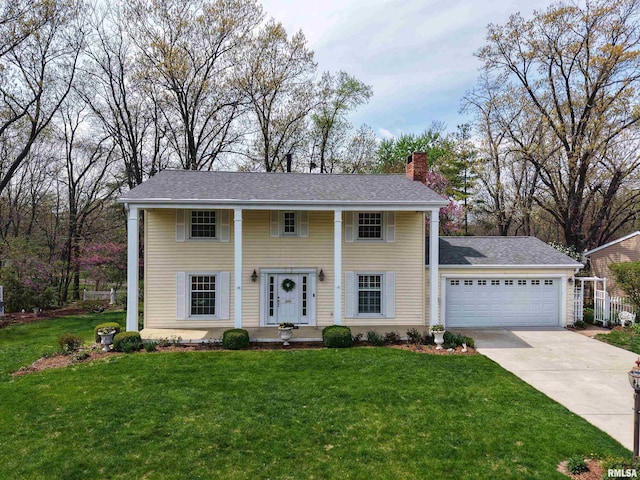 greek revival inspired property with concrete driveway, a chimney, roof with shingles, a front yard, and a garage