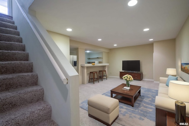 carpeted living area with baseboards, recessed lighting, and stairs