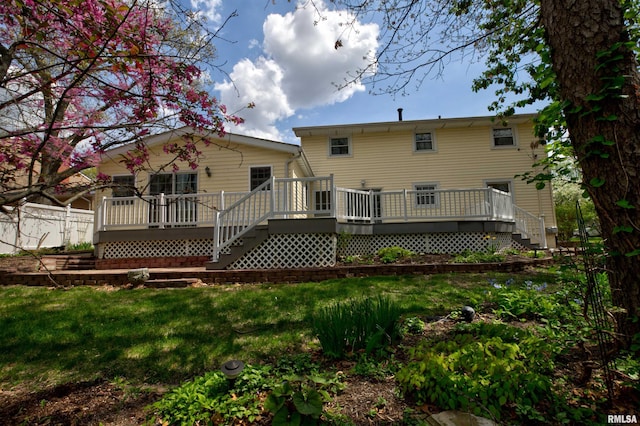 rear view of property with a deck and a yard