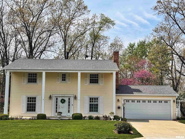 greek revival inspired property with driveway, a chimney, a front lawn, and a garage