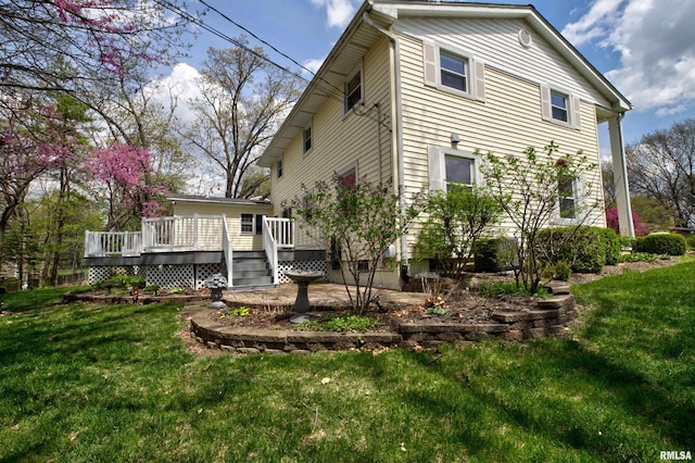 back of house with a deck and a yard