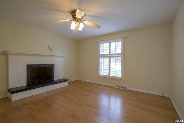 unfurnished living room featuring a fireplace, light wood-style floors, ceiling fan, and visible vents