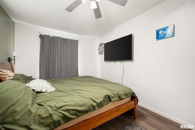bedroom with ceiling fan, wood finished floors, and baseboards