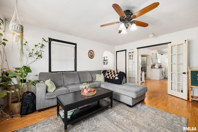 living area featuring a ceiling fan, wood finished floors, and french doors