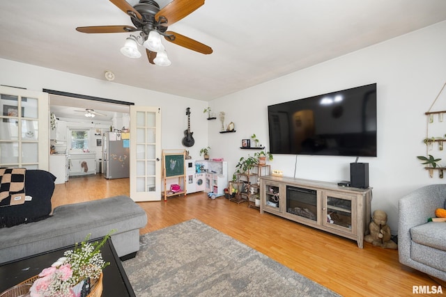 living area featuring wood finished floors, french doors, and a ceiling fan