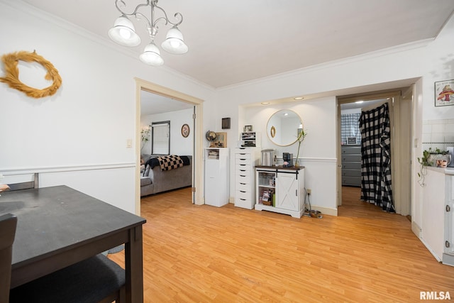 interior space with light wood-style flooring, a chandelier, and ornamental molding