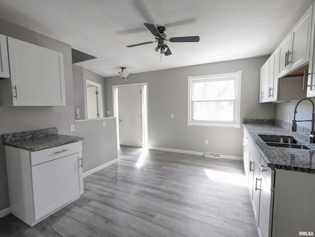 3809 N Fisk Rd, Astoria, IL 61501 - kitchen featuring a sink, dark stone countertops, ceiling fan, visible vents, and baseboards