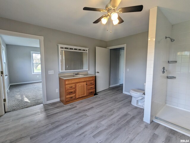 3809 N Fisk Rd, Astoria, IL 61501 - full bathroom with tiled shower, ceiling fan, toilet, and wood finished floors