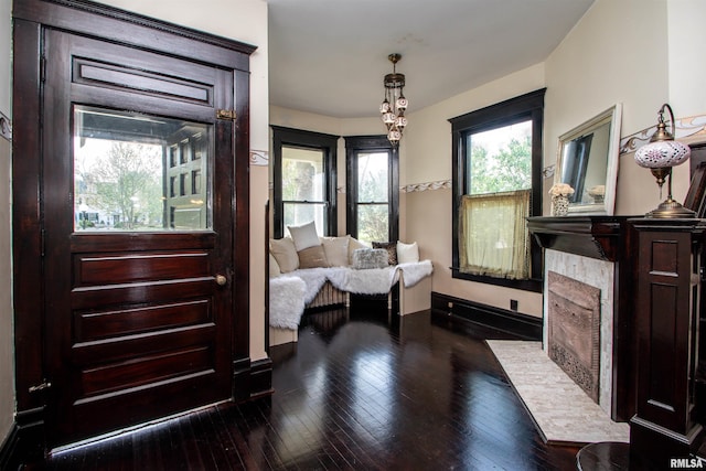 sitting room with a fireplace with flush hearth, hardwood / wood-style flooring, and baseboards