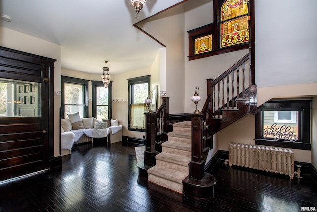 foyer entrance featuring radiator, stairs, hardwood / wood-style flooring, and baseboards