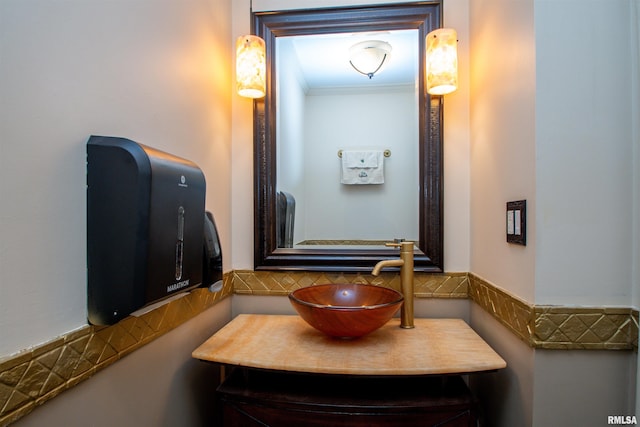 bathroom with vanity, decorative backsplash, and ornamental molding