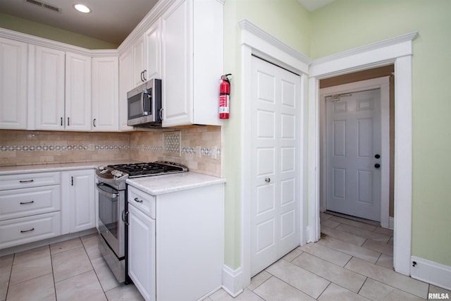 kitchen featuring light tile patterned floors, white cabinetry, stainless steel appliances, and light countertops