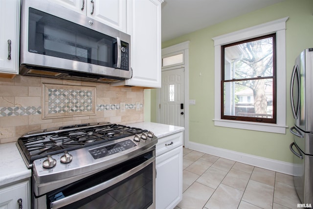 kitchen featuring stainless steel appliances, decorative backsplash, and white cabinets
