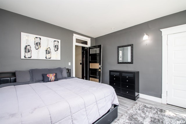 bedroom with wood finished floors and baseboards