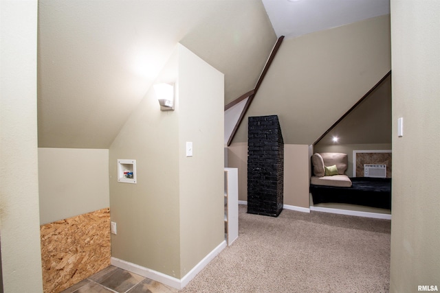 additional living space with baseboards and vaulted ceiling
