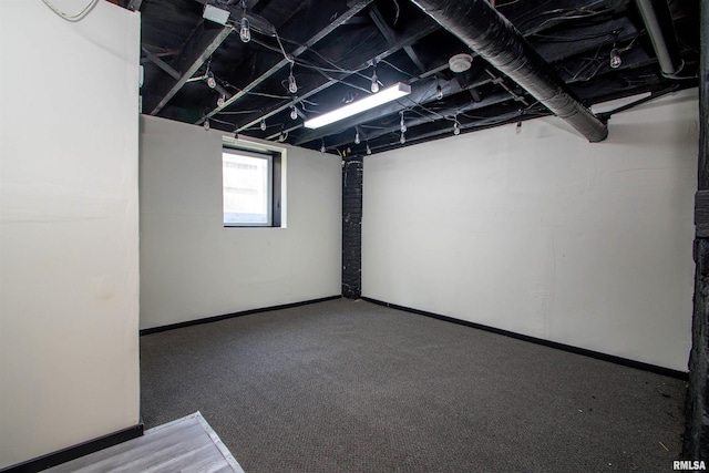 below grade area featuring carpet flooring and baseboards