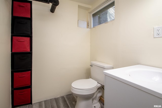 bathroom featuring toilet, wood finished floors, and vanity