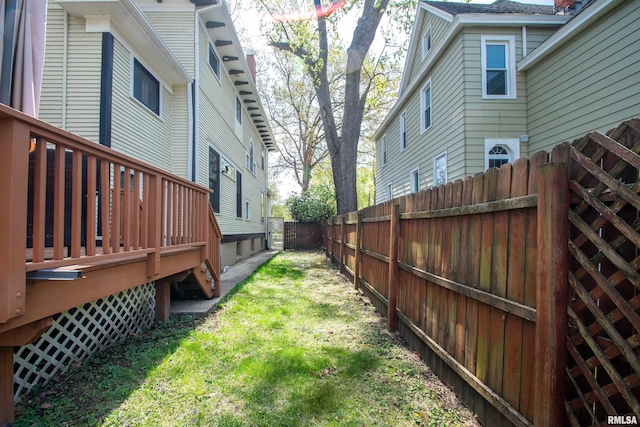 view of yard with a wooden deck and a fenced backyard