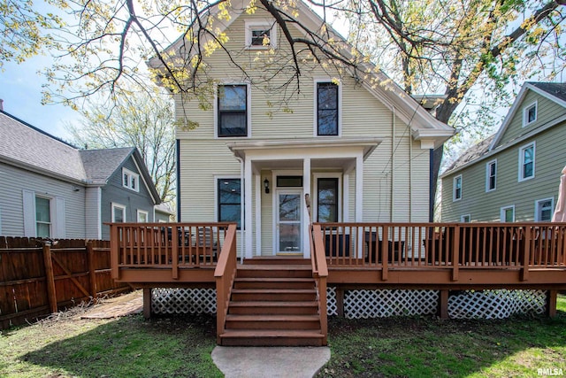 rear view of house featuring fence and a wooden deck