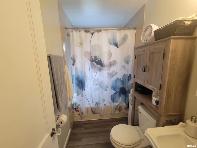 full bathroom featuring shower / bathtub combination with curtain, wood finished floors, toilet, and a sink