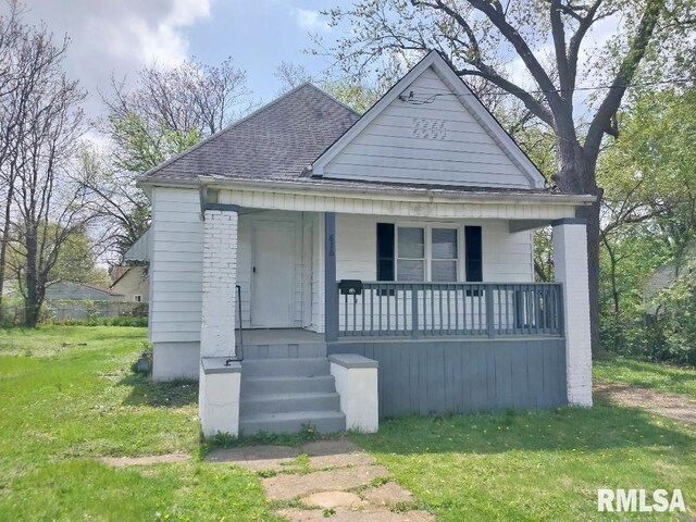 bungalow featuring a porch, roof with shingles, and a front yard