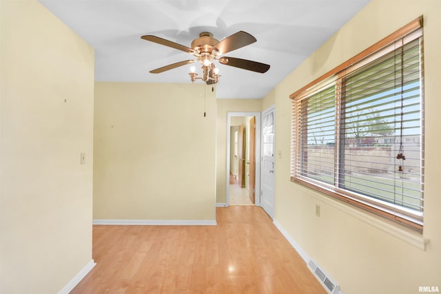 corridor featuring visible vents, baseboards, and light wood-style floors