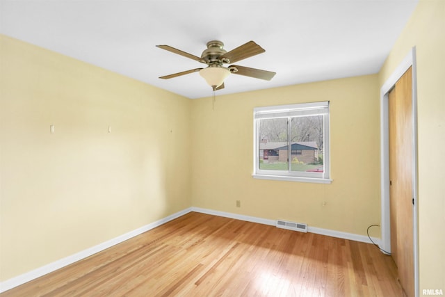 unfurnished bedroom featuring light wood-style flooring, a closet, baseboards, visible vents, and a ceiling fan