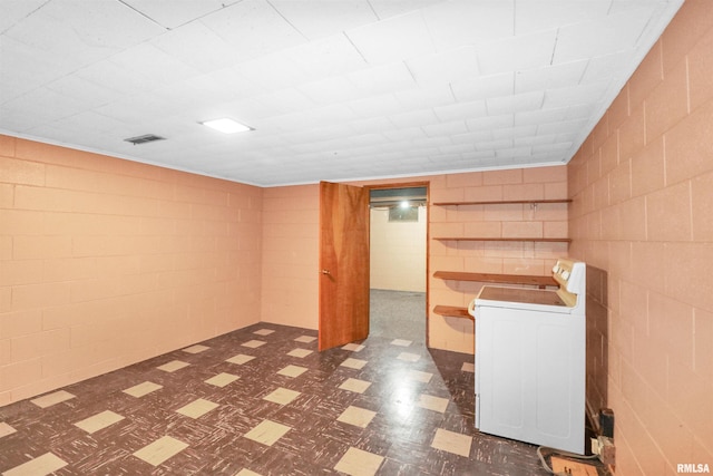 finished basement with tile patterned floors, visible vents, and washer / dryer