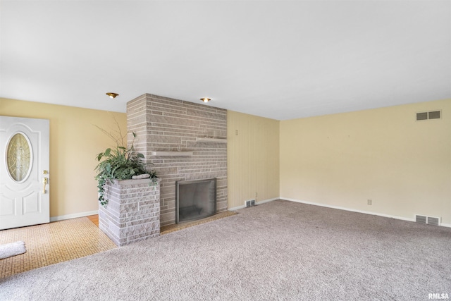 unfurnished living room featuring carpet flooring, visible vents, and baseboards
