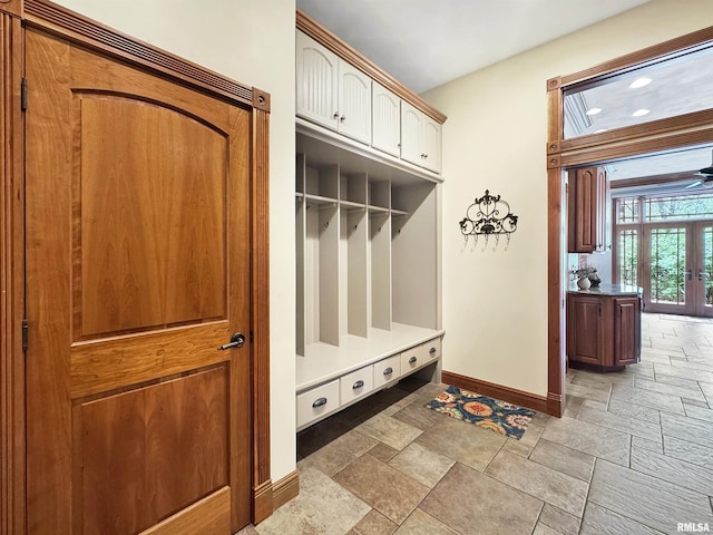 mudroom featuring stone tile floors and baseboards