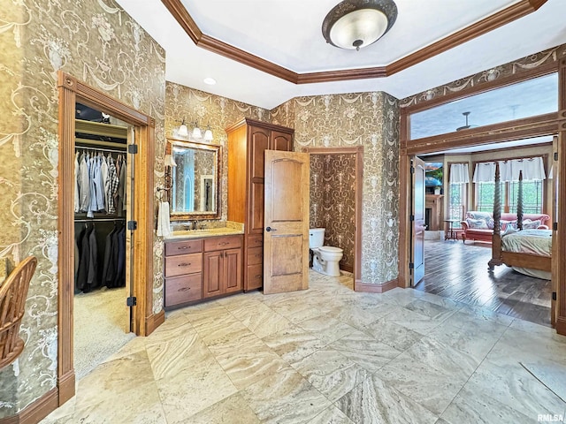 full bath with vanity, baseboards, toilet, ornamental molding, and a tray ceiling