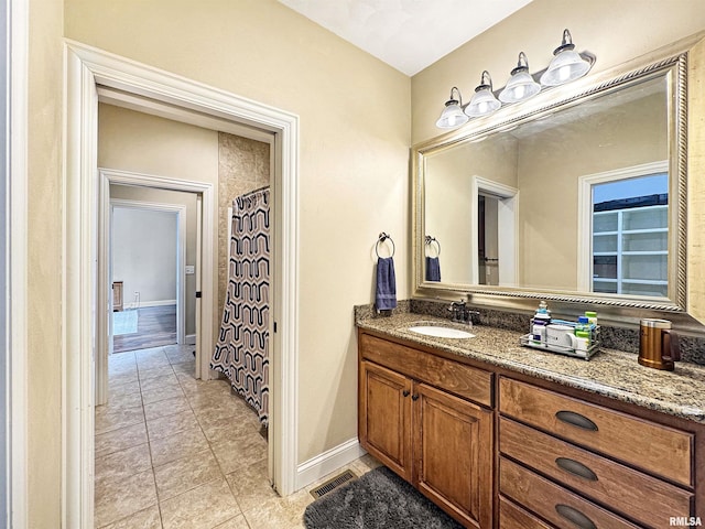bathroom with baseboards, visible vents, tile patterned floors, and vanity