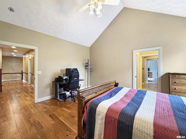 bedroom with baseboards, a ceiling fan, vaulted ceiling, and wood finished floors