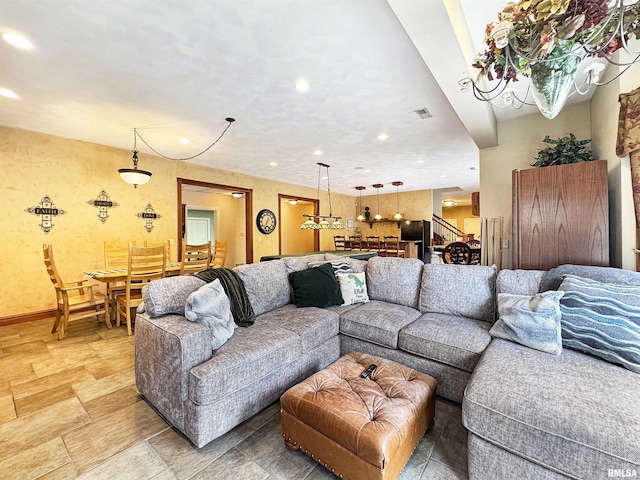 living room featuring baseboards, stone finish floor, and recessed lighting