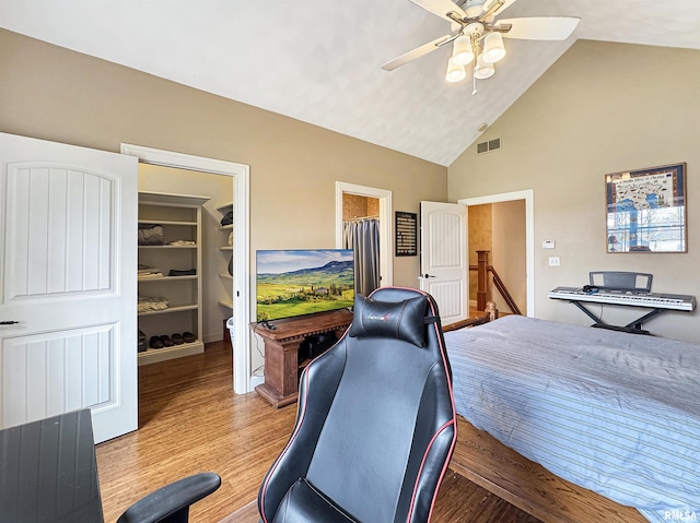 home office with ceiling fan, visible vents, light wood-style flooring, and high vaulted ceiling