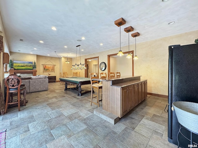 interior space with stone finish flooring, pendant lighting, baseboards, open floor plan, and recessed lighting