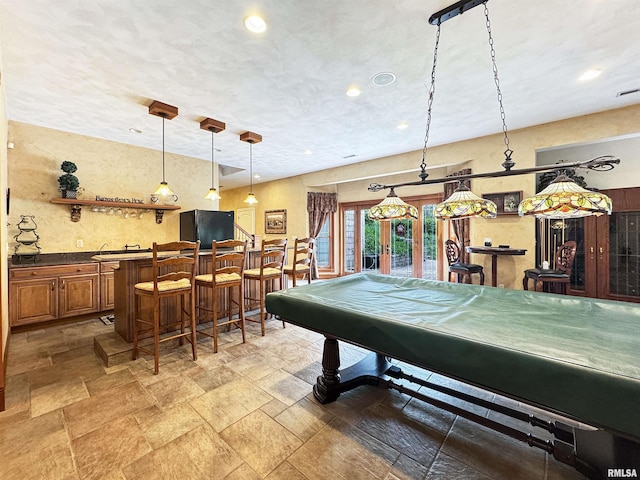 playroom with stone tile flooring, recessed lighting, pool table, and indoor bar