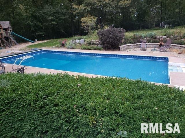 outdoor pool featuring a diving board and a patio area