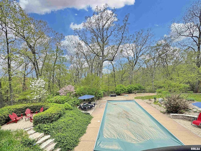 pool with a patio and fence