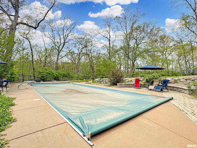 view of pool featuring a covered pool and a patio area