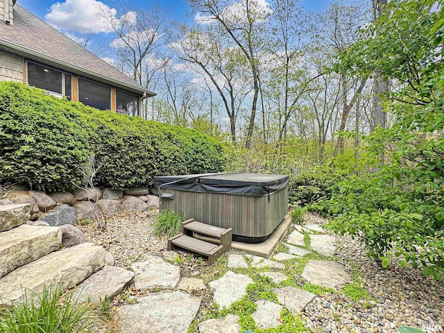 view of yard featuring a sunroom and a hot tub