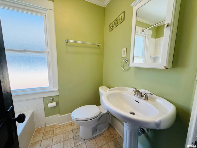 bathroom with toilet, plenty of natural light, ornamental molding, and baseboards