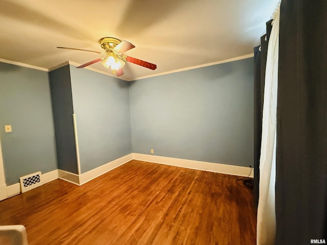 unfurnished room featuring ceiling fan, crown molding, visible vents, baseboards, and wood finished floors