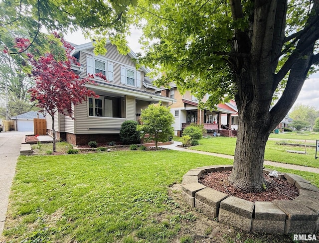 view of front of home with an outbuilding, a front lawn, a garage, and fence