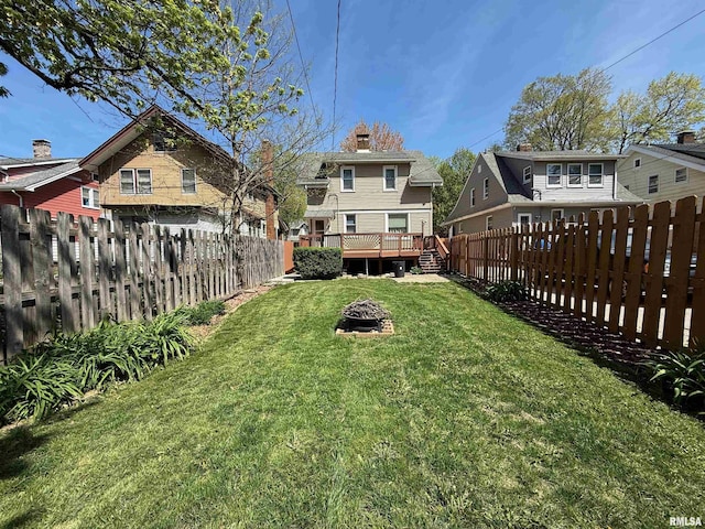 view of yard featuring an outdoor fire pit, a residential view, a wooden deck, and a fenced backyard